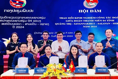 The youth unions of Quang Tri province and three Lao provinces - Savannakhet, Salavan and Sekong- sign a joint message of the friendship programme on August 28. (Photo: VNA)