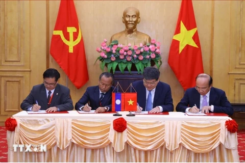 Representatives from the Ho Chi Minh National Academy of Politics, the Vietnam Academy of Social Sciences, the Lao National Academy of Politics and Public Administration, and the Lao National Institute of Economic and Social Sciences sign cooperation agreements on June 30, 2023. (Photo: VNA)