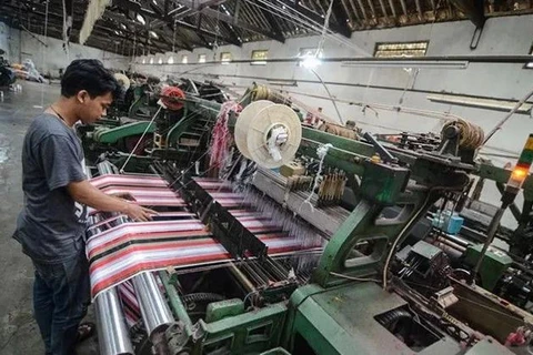 A worker completes production of sarong cloth in a textile factory in Majalaya industrial estate in Bandung regency, West Java. (Photo: Antara) 