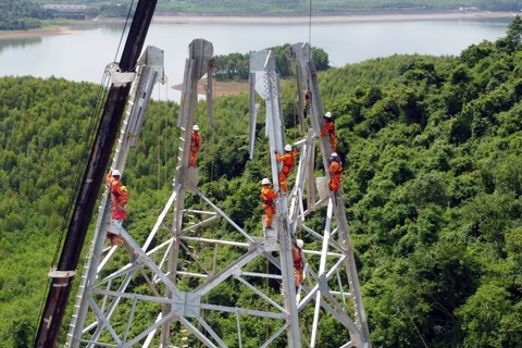 Workers persevere through sun and rain to complete transmission line