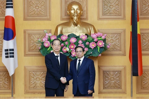 Prime Minister Pham Minh Chinh (R) hosts a reception for his Korean counterpart Han Duck Soo. (Photo: VNA)