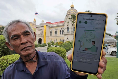 A Thai gardener shows a message on his phone in response to his registration for the digital wallet scheme. (bangkokpost.com)