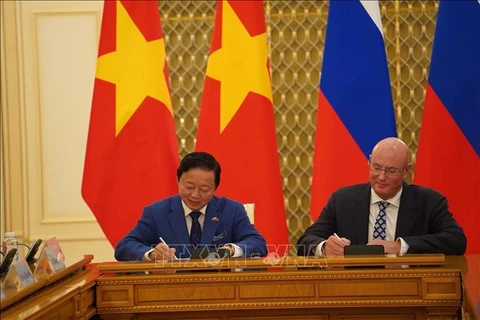 Deputy Prime Minister Tran Hong Ha (L) and his Russian counterpart Dmitry Chernyshenko sign the meeting's minute (Photo: VNA)