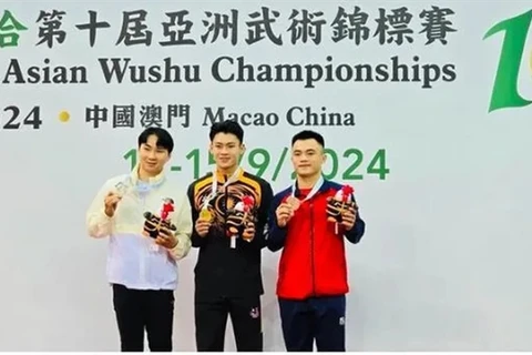 Nong Van Huu (left) poses with other medallists of the men's nanquan event at the Asian Wushu Championships on September 12 in Macau, China. (Photo of organisers)