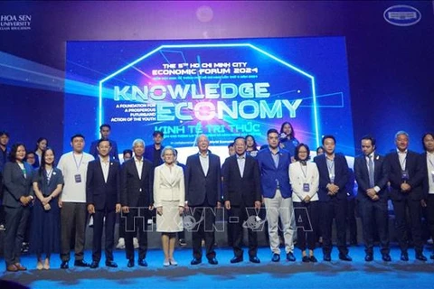 Prof. Klaus Schwab, and delegates pose for a group photo at the talkshow. (Photo: VNA)