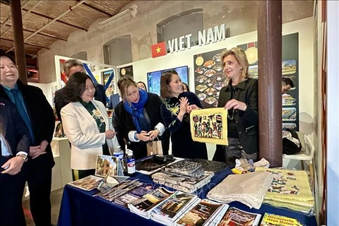 In Vietnam's exhibition area, visitors has a chance to print Dong Ho folk woodcut paintings. (Photo: VNA)