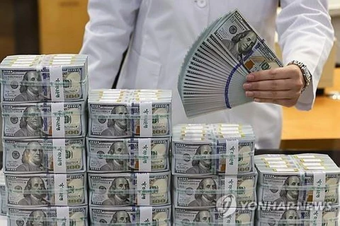 A clerk checks USD banknotes at the headquarters of Hana Bank in Seoul. (Photo: Yonhap)