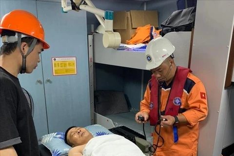 Vietnam Maritime Research and Rescue Coordination Centre’s staff provide check-ups for the Chinese sailor before brought him ashore for emergency treatment. (Photo: VNA)