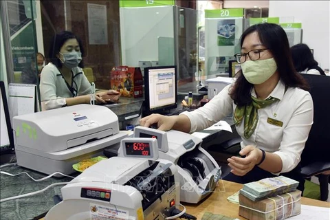 Customers make transactions at Vietcombank's head office in Hanoi. (Photo: VNA)