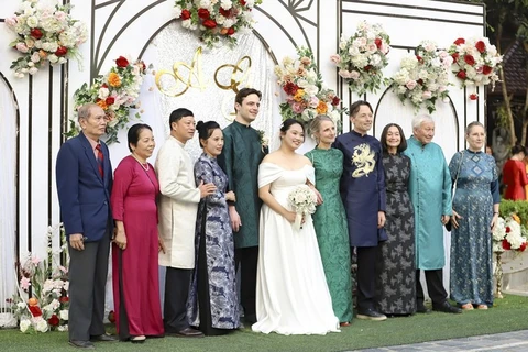 La novia Tran Ngoc Quynh Anh y el novio Guillaume Richard, junto con sus familias en el día de su boda en Dien Bien. (Foto: VOV)