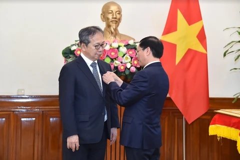 El ministro vietnamita de Relaciones Exteriores, Bui Thanh Son, entrega la medalla conmemorativa “Por la causa de la diplomacia vietnamita” al embajador japonés en Vietnam, Yamada Takio. (Fuente: TGVN)