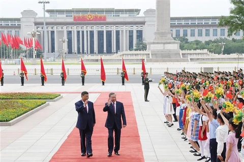 El secretario general del Partido Comunista y presidente de Vietnam, To Lam, y su homólogo chino, Xi Jinping, saludan a los niños. (Fuente: VNA)