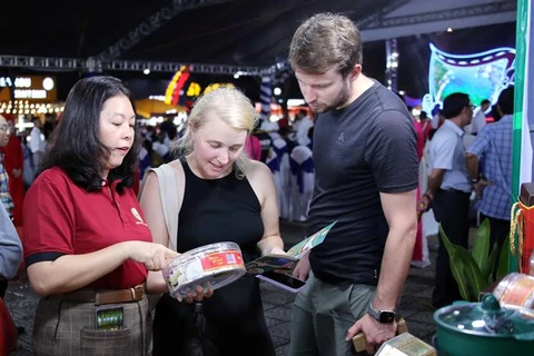 Des touristes se renseignent sur des produits de nids de salanganes de la province de Ninh Thuan lors de l'événement. Photo : VNA