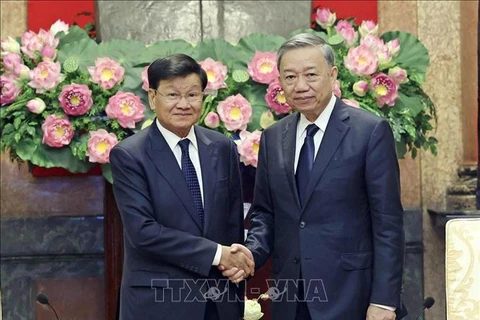 Le président To Lam (droite) et le secrétaire général du PPRL et président lao, Thongloun Sisoulith. Photo: VNA