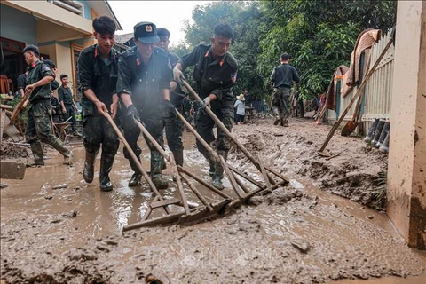 Des policiers aides des habitants de la commune de Phuc Khanh, district de Bao Yen, province de Lao Cai, à nettoyer leurs maisons après le typhon Yagi. Photo: VNA