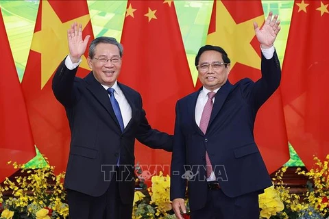 Prime Minister Pham Minh Chinh (right) and Chinese Premier Li Qiang pose for a photo before their talks in Hanoi. (Photo: VNA)