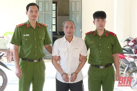 Bui Van Tuan (centre) at the police station (Photo: baothanhhoa.vn)