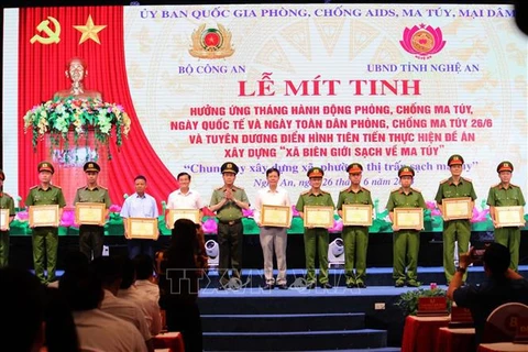 Outstanding local collectives and individuals are awarded certificates of merit by the Ministry of Public Security and the chairperson of the Nghe An provincial People's Committee at the event. (Photo: VNA)