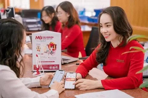 Une cliente effectue des transactions dans un bureau d'Agribank. Photo: Vietnamplus 