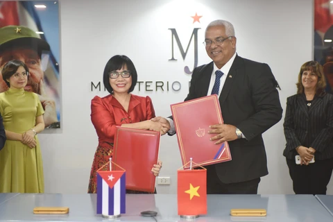 La viceministra de Justicia de Vietnam, Dang Hoang Oanh y el ministro de Justicia de Cuba, Oscar Manuel Silvera Martínez, intercambian el memorando de entendimiento sobre cooperación entre la Academia Judicial del Ministerio de Justicia de Vietnam y la Escuela Ramal del Ministerio de Justicia de Cuba (Fuente: VNA)