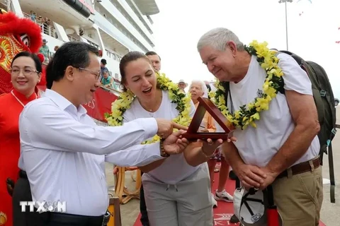 Chairman of the provincial People's Committee Cao Tuong Huy (L) presents a souvenir to David and Tina. (Photo: VNA)