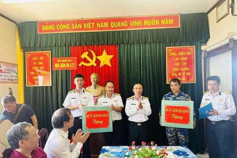 Colonel Ngo Van Thanh, Political Commissar of the Technical Department of the Navy and head of the working mission No. 21 (standing, centre), hands over presents to soldiers on DK1 Platform. (Photo: VietnamPlus)