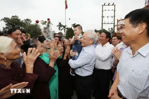 阮富仲总书记和海防市永保县荣光乡群众。图自越通社