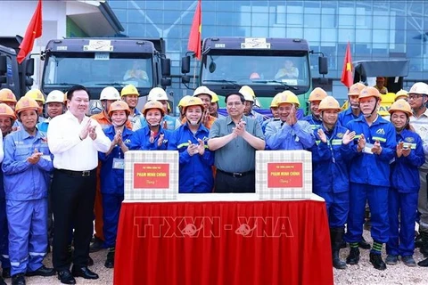 Премьер-министр Фам Минь Тьинь вручает подарки инженерам и рабочим, участвующим в строительстве терминала Т2 ханойского международного аэропорта Нойбай (Фото: ВИA)