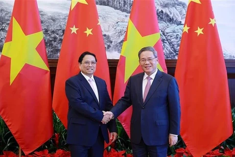 Премьер-министр Фам Минь Тьинь (слева) и премьер Госсовета КНР Ли Цян во время переговоров в городе Далянь, китайская провинция Ляонин, 24 июня. (Фото: ВИA)