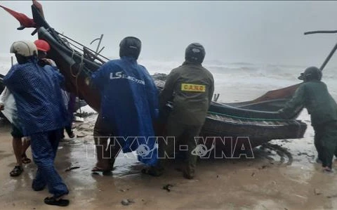 Las la provincia de Thua Thien-Hue ayudan a los pescadores a trasladar sus embarcaciones a la costa antes de que la tormenta Trami llegue a tierra firme. (Fuente: VNA)