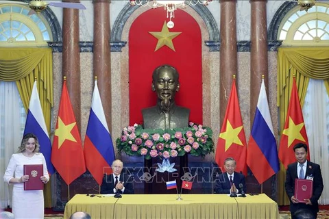 Le président vietnamien Tô Lâm (assis, à droite) et le président russe Vladimir Poutine lors de l’échange d’accords signés entre les deux pays. Photo : VNA