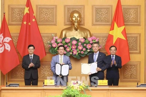 Le vice-Premier ministre Trân Luu Quang (à droite) et le chef de l'exécutif de la région administrative spéciale de Hong Kong, Lee Ka-chiu (à gauche) assistent à l'échange du protocole d'accord entre Vietnam Airlines et l'aéroport international de Hong Kong (HKIA). Photo : VNA