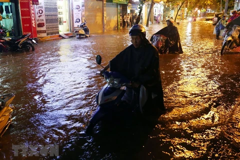 Hanoi residents wade through flood waters