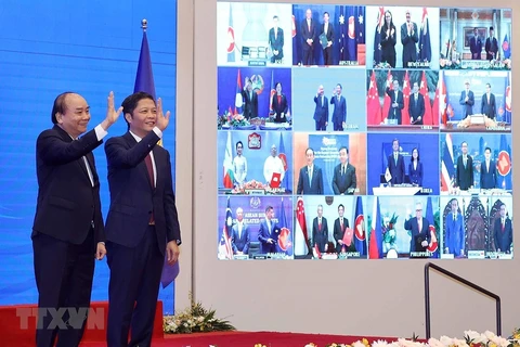 Vietnamese Prime Minister Nguyen Xuan Phuc (left) and Minister of Industry and Trade Tran Tuan Anh, together with leaders of other RCEP member countries, witness the pact signing via videoconference on November 15 (Photo: VNA)
