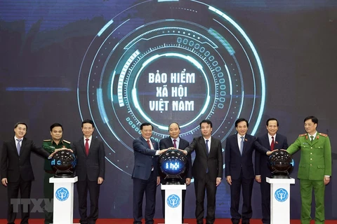 Prime Minister Nguyen Xuan Phuc and other delegates press the button to launch the “VssID - Digital Social Insurance” application (Photo: VNA)