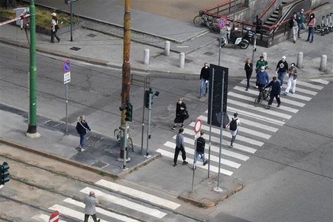 People cross a street in Milan city of Italy (Photo: Xinhua/VNA)