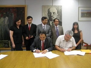 Representatives of the Communist Review and SolidNet sign a MOU (Source: VNA)
