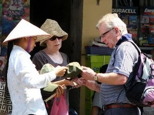 A foreign tourist buys souvenirs in Hanoi's streets. (Source: VNA)