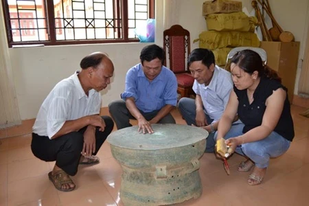 Archaeologists discuss the newly-found bronze drum from northern province of Bac Kan. Photo courtesy of Trinh Nang Chung. 