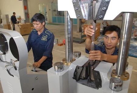 Engineers at T-Tech Viet Nam Co check laboratory equipment. Photo: VNA