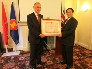 Deputy FM Son presented the Friendship Order to former UK Ambassador Warrick Morris (Source: VNA)