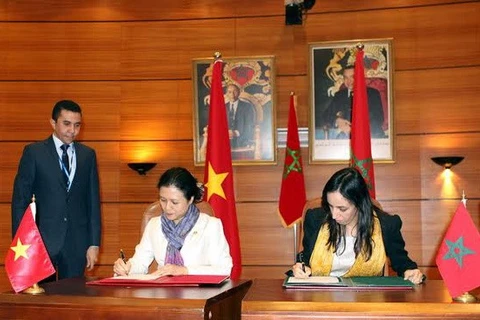 Nguyen Phuong Nga and Mbarka Bouiada sign a meeting minute (Photo: VNA)
