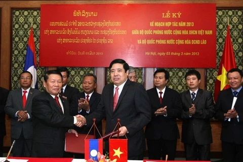 Defence Minister Phung Quang Thanh (R) and his Lao counterpart at a signing ceremony for 2013 cooperation agreement. Photo: VNA