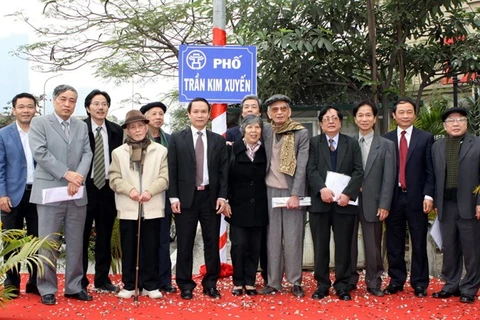 Leaders of Vietnam News Agency and Tran Kim Xuyen martyr's family stand in the street (Source: VNA)