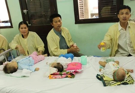 Three children share a bed at the National Paediatric Hospital. The hospital has been trying to cope with overcrowding for two months. — VNA Photo