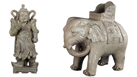 A white glazed elephant (right) fromthe Nguyen dynasty in the 19th century and a glazed statue of the pagoda guardian that dates back to the 17th century.