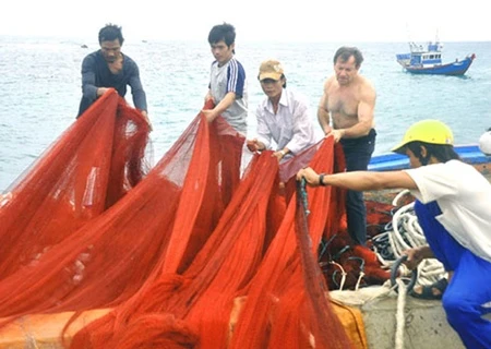 Andre Menras (bare chested) goes fishing with Ly Son islanders. A documentary about him will be screened for Ha Noi audiences (Photo: vnexpress.net)