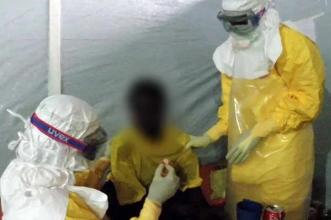 Doctors give treatment to an Ebola infected patient in Guinea on March 31 (Photo: AFP/VNA) 