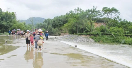 Local people pass the Tan Ap spillway of Phuc Thuan commune, Pho Yen district, Thai Nguyen province (Source: VNA)