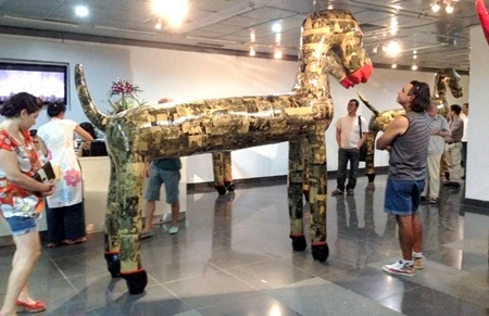 Visitors study a sculpture at L'Espace, Hanoi (Photo: VNA)